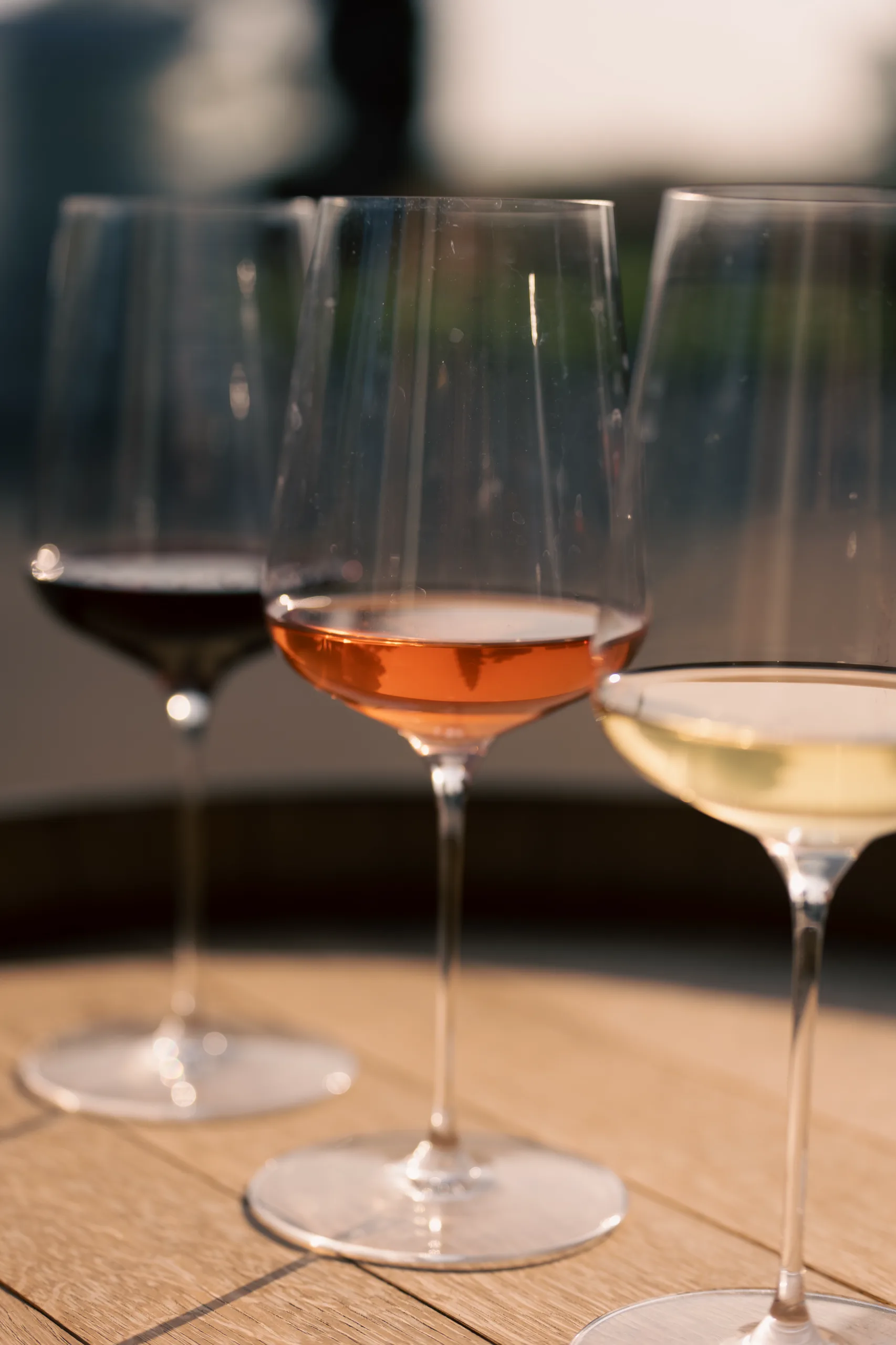 Trois verres de vin rouge, rosé et blanc, en lumière naturelle