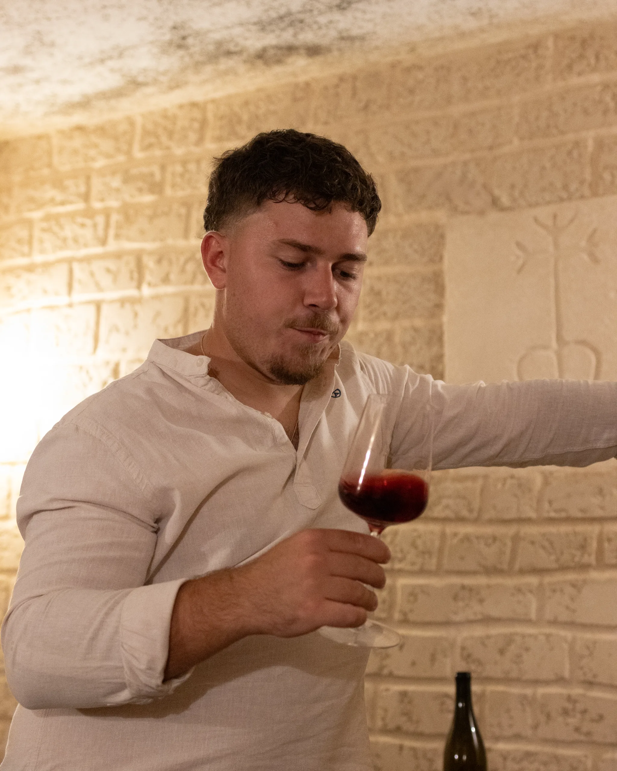 Numa Rouvier examinant un verre de vin rouge